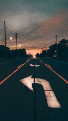 the sun is setting on an empty street