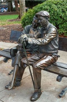 a statue of a man sitting on top of a bench