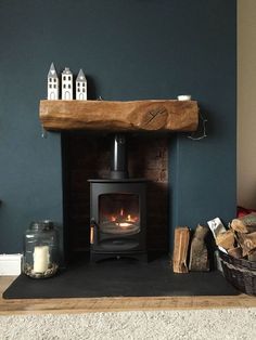 a wood burning stove sitting inside of a living room next to a pile of logs