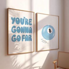 two posters on the wall in an empty room with a chair next to them and a pool ball