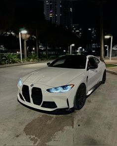 a white sports car parked on the street at night