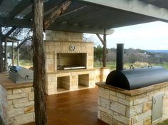 an outdoor bbq area with stone walls and grill