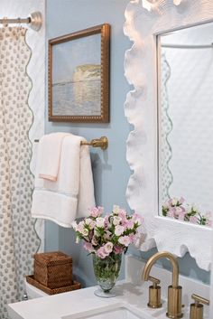 a white sink sitting under a bathroom mirror