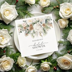 a white plate topped with flowers and greenery next to a card that says elizabeth's bridal shower