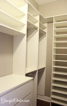 an empty walk in closet with white shelving