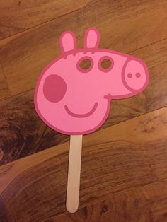 a pink cow shaped popsicle on top of a wooden floor next to a wood floor