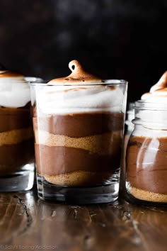 three desserts in glass containers on a table