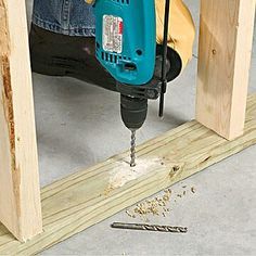 a driller is being used to attach the base of a piece of plywood