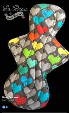 an oven mitt with hearts on it and the words love is in the background