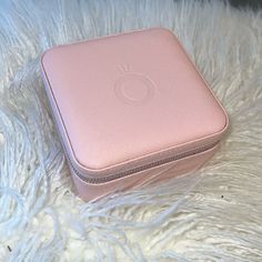 a pink case sitting on top of a white fur covered floor