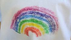 there is a rainbow made out of crochet on top of a white cloth