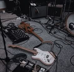 guitars and amps are sitting on the floor next to each other in a recording studio