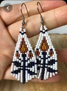 a pair of beaded earrings in white and brown