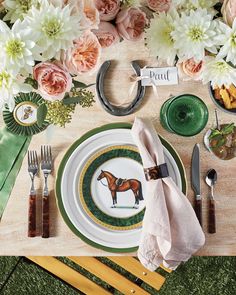 a place setting with flowers and napkins on the table for an equestrian themed dinner