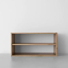 an empty wooden shelf against a white wall