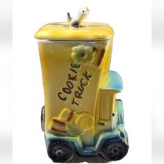 a cookie truck figurine is shown with a bird on the top of it