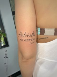 a woman with a tattoo on her arm that reads, autonefla xxximixviii