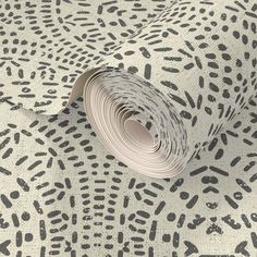 an animal print wallpaper with black and white spots on it's surface, including a roll of paper