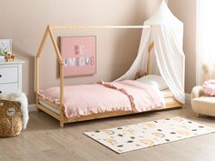 a child's bedroom with pink walls and white furniture, including a canopy bed