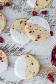 cranberry white chocolate cookies with icing and dried cherries on a wooden table