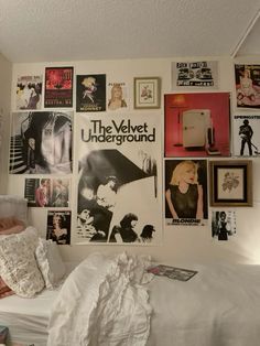 a bedroom with posters on the wall and bed