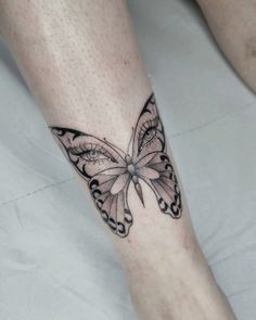 a woman's leg with a butterfly tattoo on it