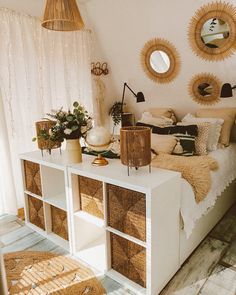 a bedroom with wicker baskets on the bed and round mirrors hanging from the ceiling