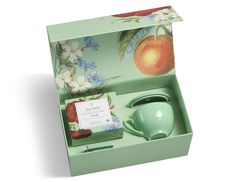 a tea set in a green box with flowers on it