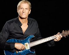 a man holding a blue guitar in his right hand