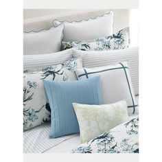 a bed covered in blue and white pillows