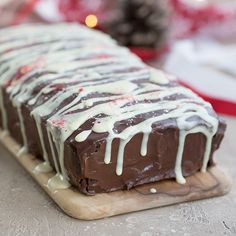 chocolate peppermint pound cake with white icing on a cutting board next to pine cones