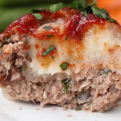 a close up of a plate of food with meat and sauces on the top