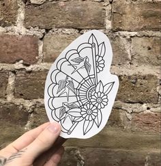 a hand holding up a sticker with flowers on it