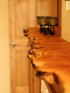 a close up of a wooden table with vases on the wall in the background