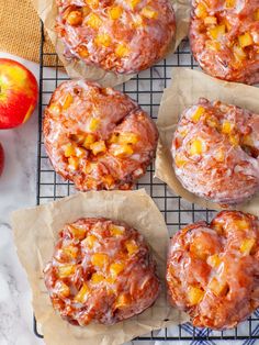 apples and muffins are sitting on a cooling rack next to an apple slice