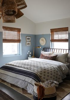 a bed sitting in a bedroom next to two windows