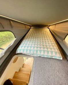 the inside of a camper with a bed in it