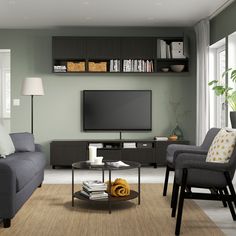 a living room filled with furniture and a flat screen tv mounted on a wall above a coffee table