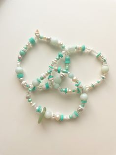 "the \"sea treasures\" bracelets are made by tons of different charms and beads. they're a very unique set of bracelets that are perfect for any summer look don't wear this in the water, the knot will come undone. please don't stretch it, it will break. not recommended for children under 8 as small objects could present as a choking hazard." Bohemian Charm Bracelet With Round Beads For Beach, Adjustable Ocean-inspired Beaded Bracelets With Lobster Clasp, Ocean-inspired Bracelets With Colorful Beads For Gifts, Ocean-inspired Bracelets With Colorful Beads As Gifts, Ocean-inspired Beaded Bracelet For Beach Season, Bohemian Bracelets With Lobster Clasp For Beach, Ocean-inspired Beaded Bracelets With Round Beads, Handmade Turquoise Beaded Bracelets In Ocean Style, Ocean-inspired Beaded Round Bracelets