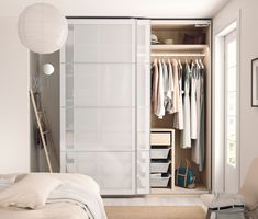 an open closet with clothes hanging on the doors and drawers, along with other items