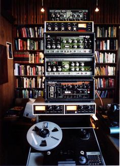 an old stereo system sitting on top of a table in front of a bookshelf