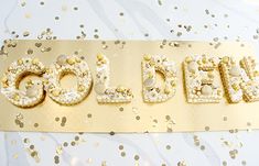 the word gold spelled out in white and gold glitters