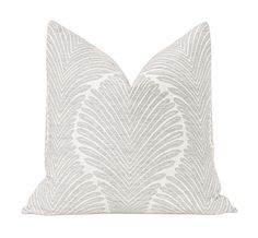 a grey and white pillow with an intricate design on the front, featuring a feathered pattern