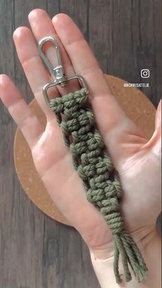 a hand holding a green crochet keychain