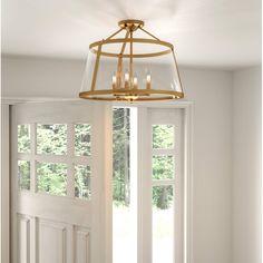 a chandelier hanging from the ceiling in a room with white walls and windows