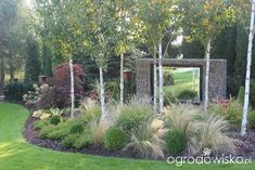 an outdoor garden with trees, shrubs and flowers in the background is a large mirror