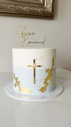 a white and gold cake with a cross on top