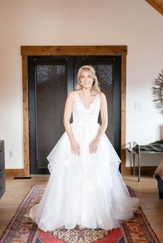 a woman in a wedding dress standing on a rug