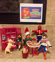 some toys are sitting on the floor in front of a christmas party sign and fireplace