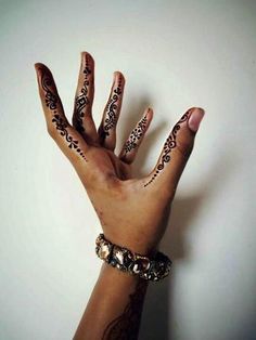 a person's hand with henna tattoos on it